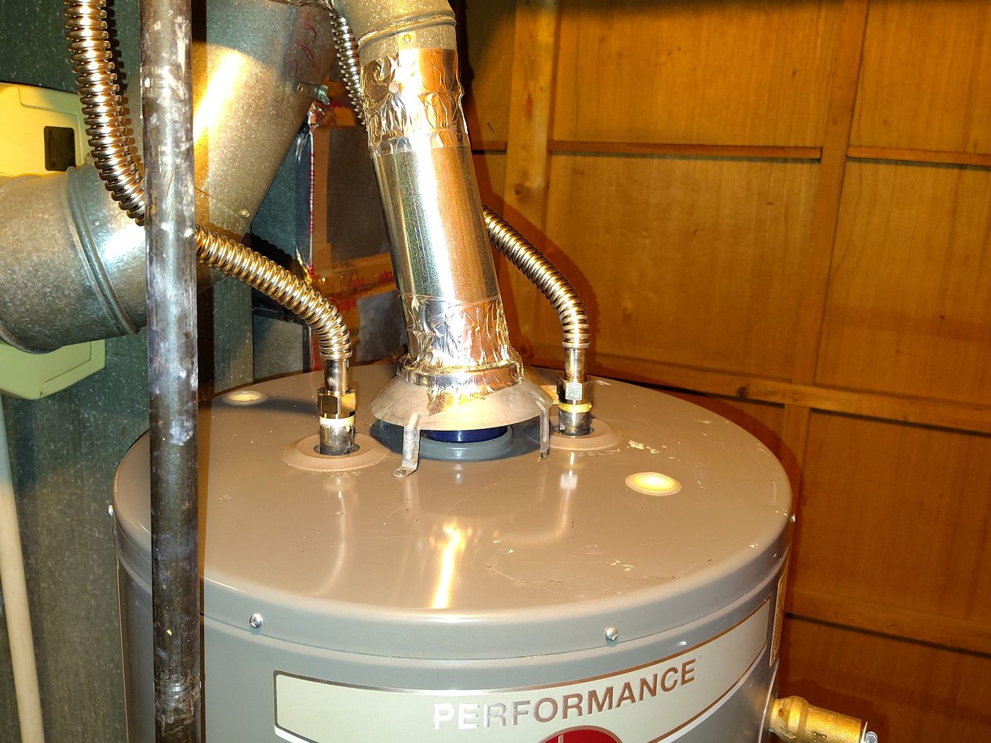 A gas water heater with new flexible supply connectors and a freshly sealed flue